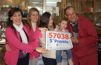 Los empleados del estanco lucen orgullosos el cartel con el número agraciado. (Foto: Carlos Granda)