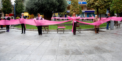 Voluntarios despliegan un lazo rosa en la Plaza de la Trinidad.