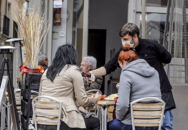 Un camarero atiende a dos clientas en una terraza. - Rober Solsona - Europa Press - Archivo