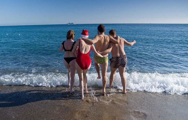 Jóvenes se bañan en la playa de la Barceloneta, a 25 de diciembre de 2022, en Barcelona (España)