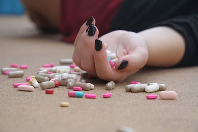 La mano de una mujer con varias pastillas o fármacos / PIXABAY