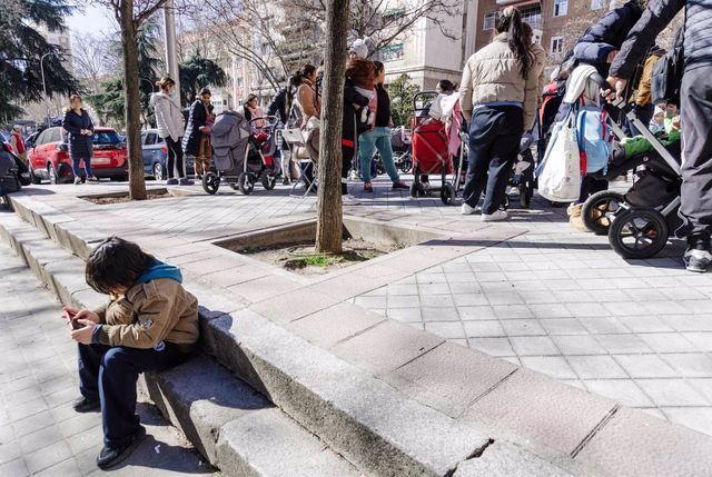 Un grupo de persona espera una cola durante la entrega de ropa de abrigo y zapatos nuevos a niños vulnerables. - Carlos Luján - Europa Press - Archivo