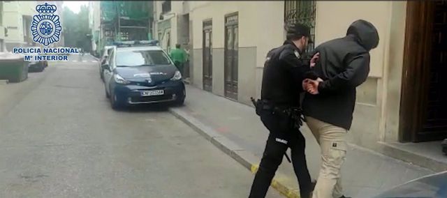 Un agente custodia a uno de los detenidos. - POLICÍA NACIONAL