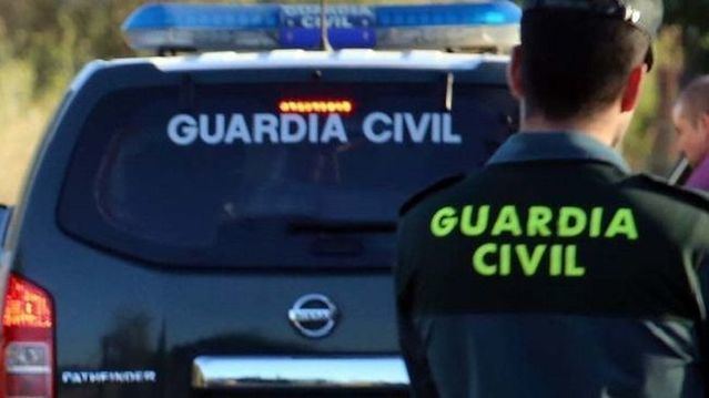 Agente y vehículo de la Guardia Civil.