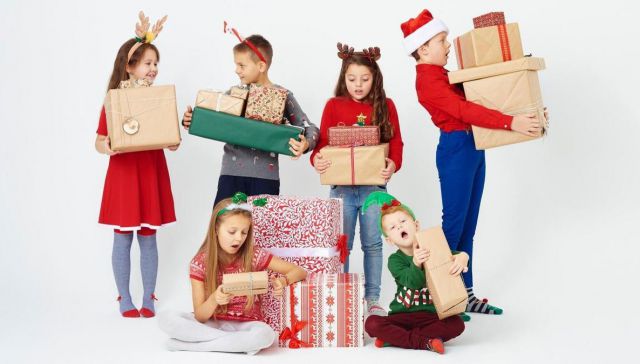 Un grupo de niños y niñas con los regalos navideños / Foto: FREEPIK