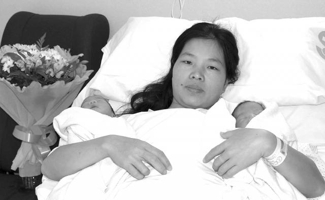 Los gemelos Xiaoyue y Xiaoli con su madre Jiang Ping