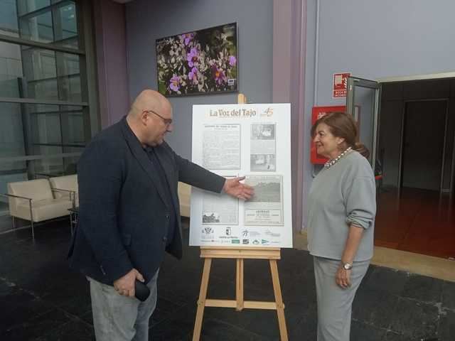 Carmen Amores y Alberto Retana junto a uno de los paneles de la exposición 'Así nació CLM'