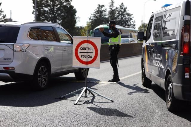 Un agente de Policía Nacional da el alto a un vehículo en un control