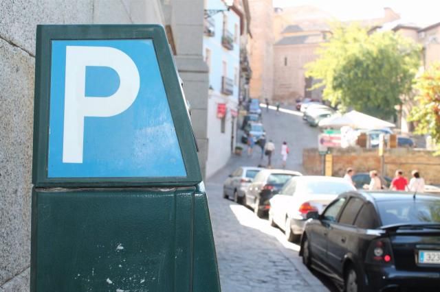 Plano detalle de un parquímetro, con coches de fondo.