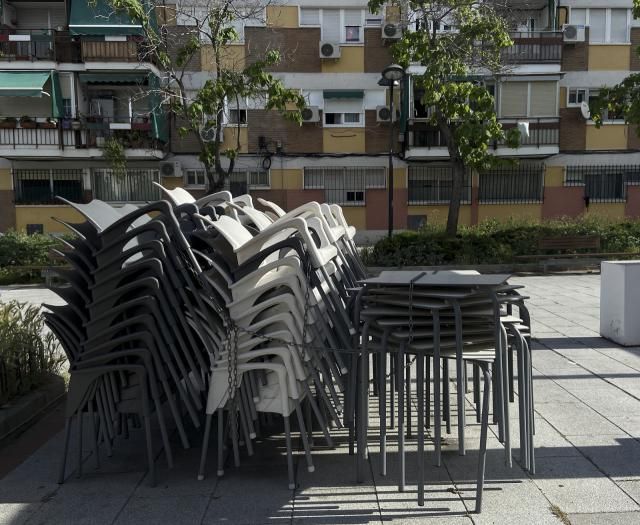 Sillas y mesas apiladas en una terraza cerrada | Archivo 